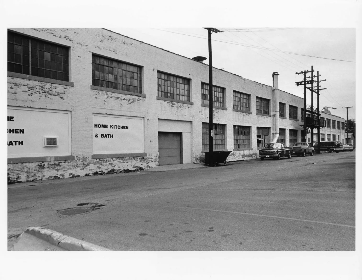 Black-and-white photographs of the Buescher Band Instrument Company Building, 1986: Front Elevation with Loading Dock (1986)